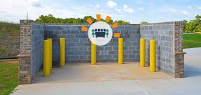 Concrete block waste enclosure with yellow bollards